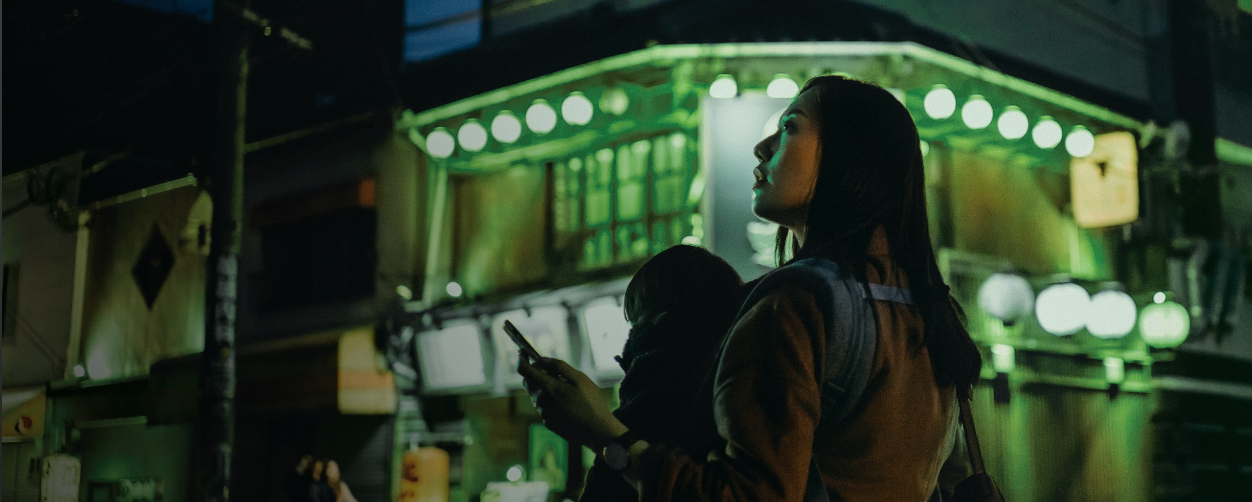 Green lit street featuring a woman Green lit street featuring a woman